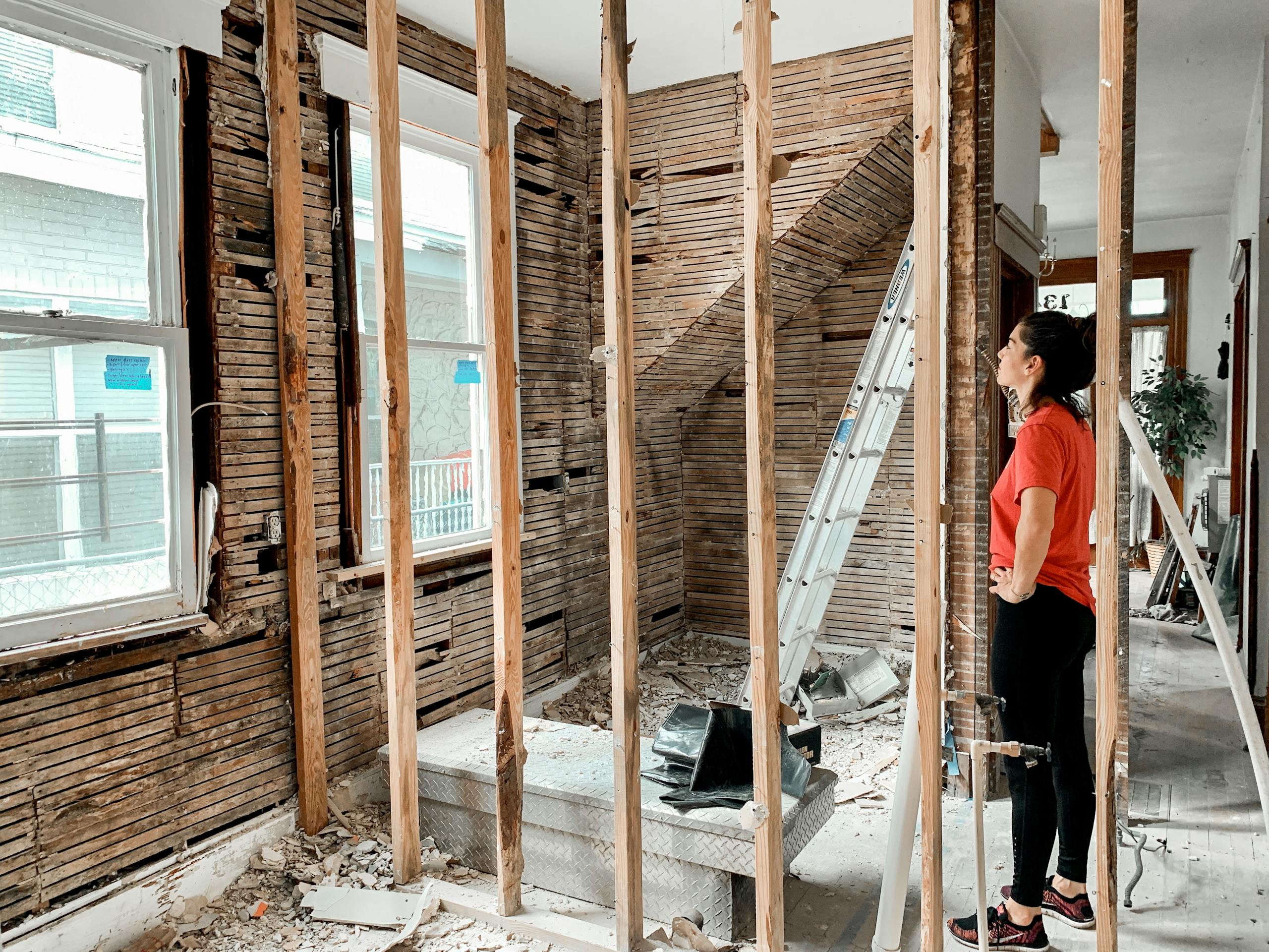 Woman observing home renovation progress indoors.